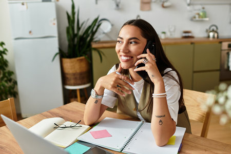 A beautiful young woman relaxes at home, engaged in a friendly phone conversation, smiling.の写真素材