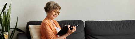 In a cozy room, an older woman writes in her journal, savoring a peaceful afternoon.の写真素材