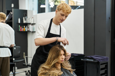 A skilled stylist enhancing a clients hair, illustrating current beauty trends in a chic salon.の写真素材