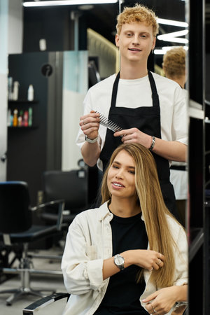 A talented stylist works on a clients hair, showcasing the latest trends in a modern beauty salon.の写真素材