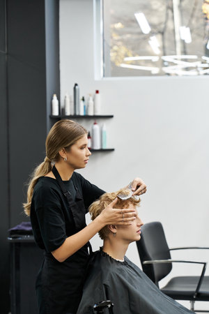 Stylist focuses intently on perfecting a fresh haircut for the client in a chic salon.の写真素材