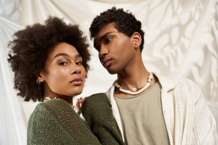 Couple exuding romance, sharing an intimate moment against a soft and simple backdrop.