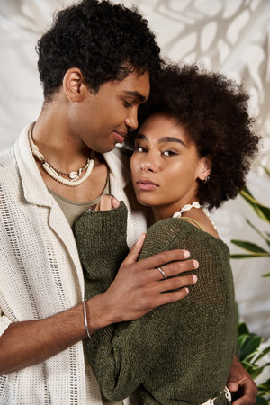 A young couple embraces, radiating love while captured in a cozy, aesthetic environment.の写真素材