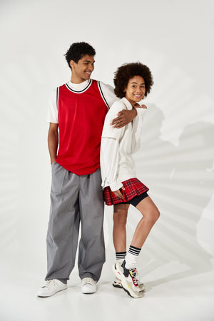Two young people share love and joy, flaunting their unique styles and bond.
