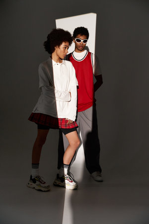 Stylish young couple showcases their love and aesthetic charm amidst dramatic lighting and shadows.