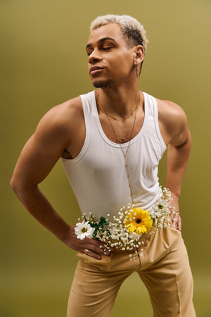 A stylish young African American man poses confidently in a chic tank top adorned with flowers.の写真素材