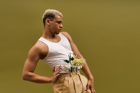 A stylish young African American man showcases confidence in a tank top adorned with flowers.の写真素材