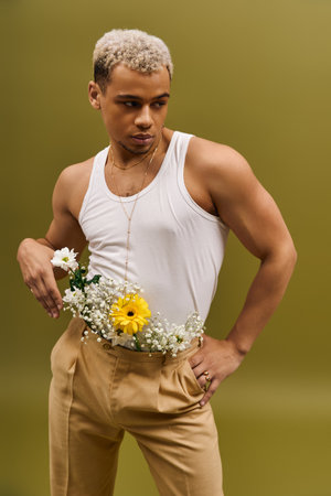 A stylish young man confidently poses in a floral tank top, showcasing youthful diversity.の写真素材