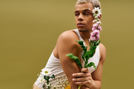 A young african american man showcases his trendy look with dyed hair and flowers in a studio.