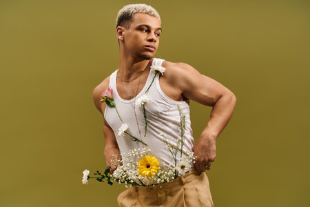A fashionable young man showcases his style with dyed hair and flowers in a studio setting.の写真素材