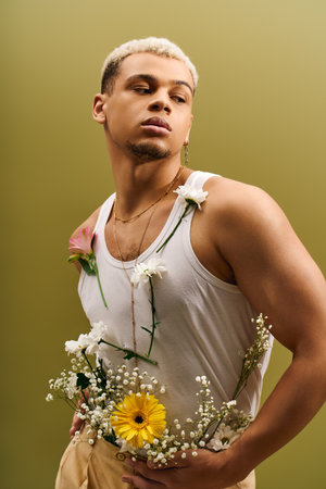 A young and handsome African American man showcases his style with flowers in a bright studio space.の写真素材