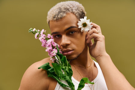 A young man with dyed hair showcases a trendy look holding flowers in a studio.