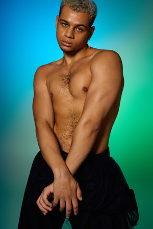 A muscular young man strikes a pose with confidence, showcasing his dyed hair and artistic flair.の写真素材
