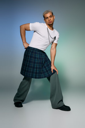 A young man with dyed hair models a stylish outfit, blending elegance and urban flair in a studio.の写真素材