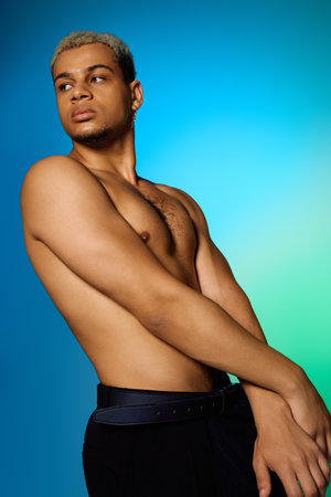 A young African American man showcases his muscular physique with dyed hair in a studio setting.の写真素材