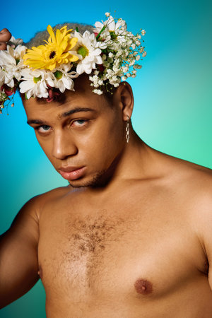Shirtless young African American man poses confidently in a studio adorned with flowers.の写真素材