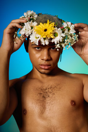 A shirtless young African American man poses confidently in a studio, adorned with flowers.の写真素材