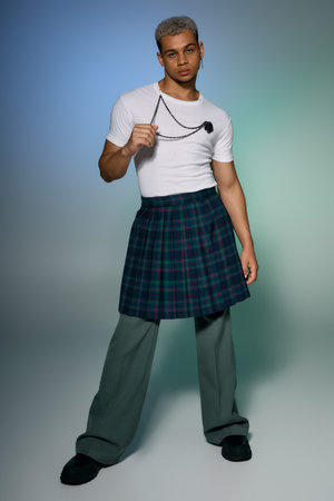 A young African American man stands confidently, showcasing creativity in fashion.の写真素材