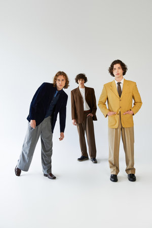 Friends express individuality in bold suits, enjoying a moment of camaraderie and style together.の写真素材