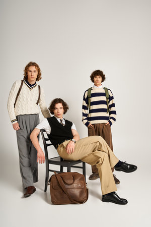 Three young men pose in a bright studio, showcasing their modern outfits and unique styles.