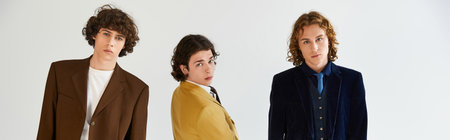 Stylish young men pose together sharing smiles and showcasing their unique fashion sense.