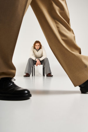 Two fashionable young men showcase their unique styles and playful energy in a chic studio.の写真素材