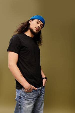 A bearded young man stands with a relaxed posture, showcasing his style and charisma.