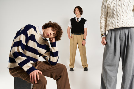 Fashionable young men share a moment of camaraderie while showing off their trendy attire.