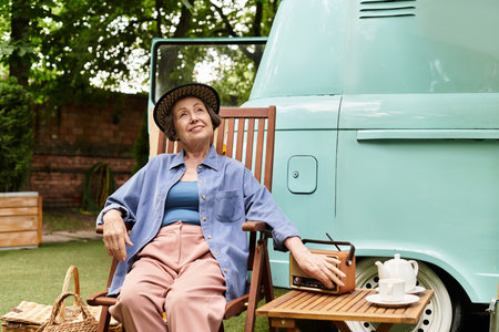 A beautiful senior woman relaxes in a garden, embracing the peaceful atmosphere and natures charm.