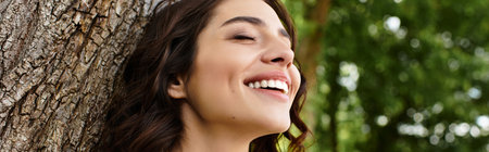 Wavy brown-haired woman smiles brightly while relaxing outdoors on a sunny summer day, bannerの写真素材