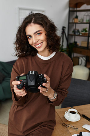 Curly-haired freelancer enjoys capturing moments in her cozy home workspace.の写真素材