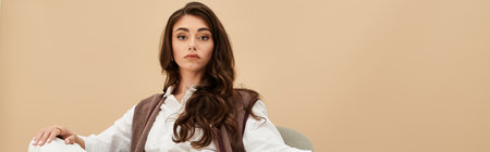 A beautiful young woman showcases her fashionable outfit amidst a chic studio backdrop, bannerの写真素材