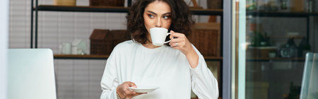 Freelancer relishes a moment of calm sipping coffee in her cozy home workspace, banner