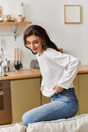 In her stylish apartment, a young woman with brown hair takes a peaceful break on the couch.