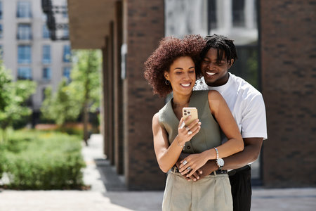 Young couple spends a lovely summer day in the urban setting, sharing smiles and affection.の写真素材