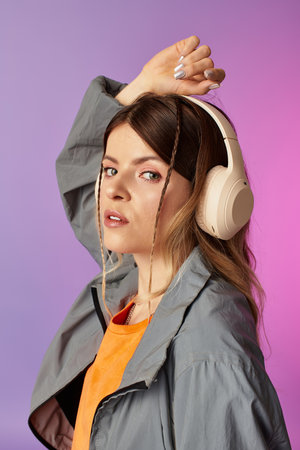 Confident young woman vibes to the music while showcasing a trendy summer fashion statement.