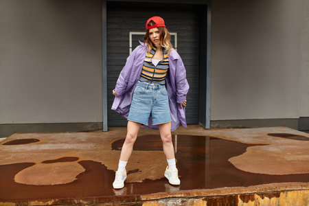 Bright summer day finds a confident young woman posing in trendy casual attire, radiating energy.の写真素材