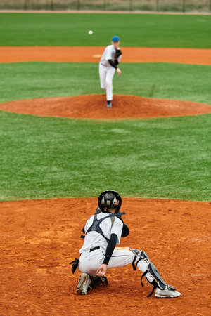 Two teenage boys are engaged in an exciting baseball game on a bright, sunny day.の写真素材
