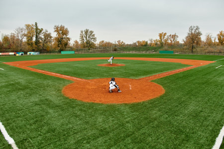 Two teens play an exciting baseball game on a bright green field, celebrating youth sports.の写真素材