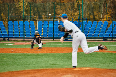 Two teenage boys passionately engage in a baseball practice session on a lively field.の写真素材