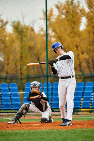 Two teenage boys engage in baseball play on a lively field adorned with trees in autumn hues.
