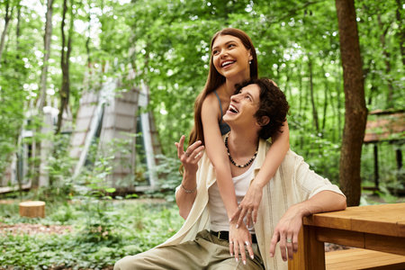 In a serene park setting, a young couple shares laughter and love while relaxing together.の写真素材