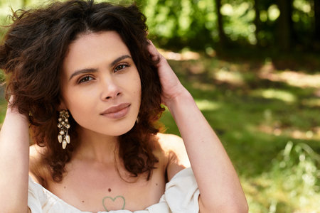 Youthful beauty in a white summer dress embraces nature in a green village park setting.の写真素材