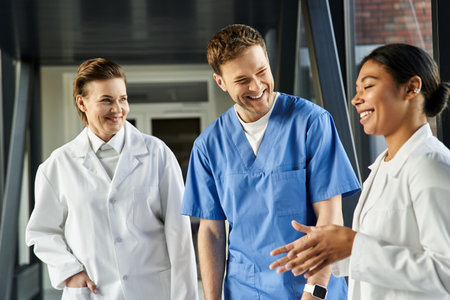 Three diverse medical professionals discuss strategies in a modern hospital.の写真素材