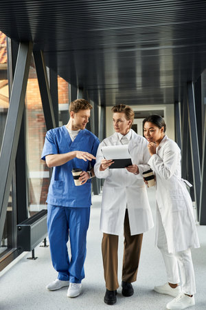 Three multicultural doctors engage in a discussion while reviewing data together.の写真素材