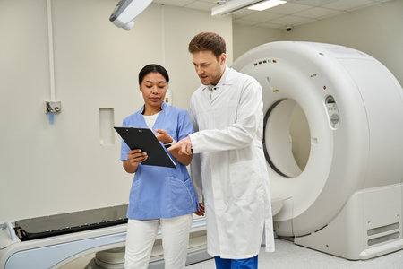 Two doctors review patient results while working in a modern hospital.