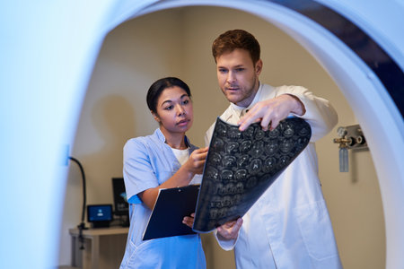 Two dedicated doctors examine MRI scans together in a state-of-the-art healthcare facility.