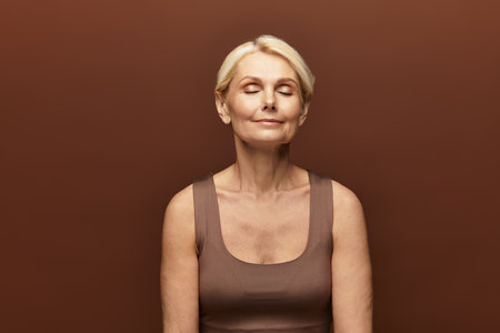 A beautiful senior woman enjoys a moment of tranquility with closed eyes, radiating bliss.の写真素材