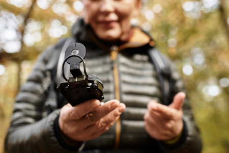 Senior woman enjoys a peaceful hike in the forest while checking her navigation device.の写真素材