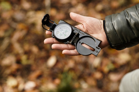 Senior woman enjoys a peaceful hike in the forest, checking her compass among vibrant foliage.の写真素材